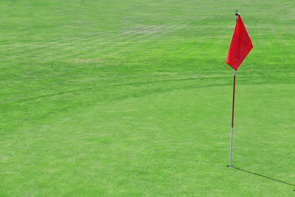 Campo de golfe verde com bandeira vermelha — Fotografia de Stock