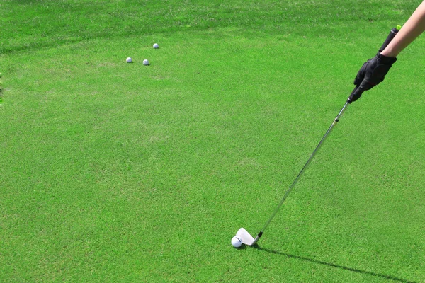 Mão na luva preta com clube de golfe e bola — Fotografia de Stock