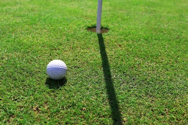 Balle de golf sur lèvre de tasse — Photo