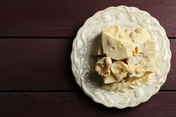 Witte chocolade stukjes met noten op plaat — Stockfoto