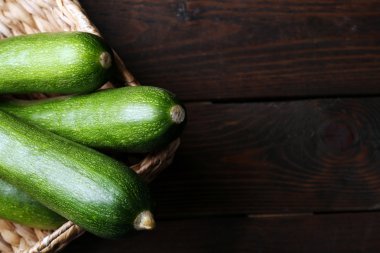 Ahşap arka plan üzerinde hasır sepet içinde taze kabak