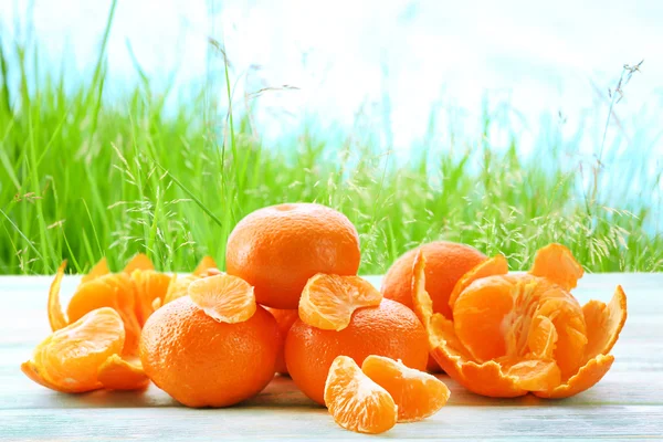 Mandarines mûres sur table en bois sur fond de nature floue — Photo