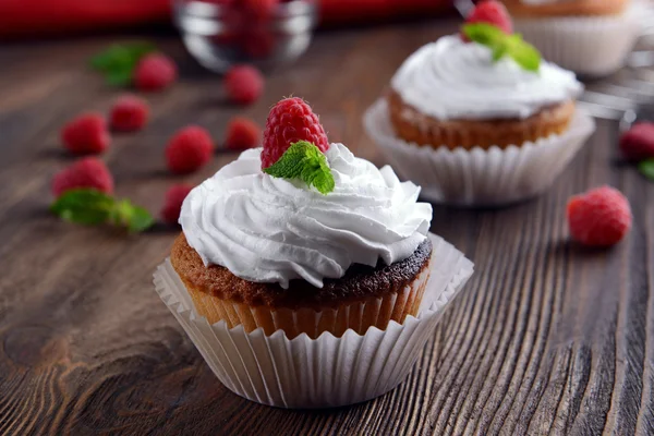 Leckere Cupcakes mit Beeren und frischer Minze auf Holztisch aus nächster Nähe — Stockfoto