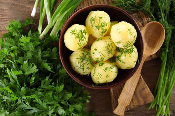 Batatas fervidas com verdes em boliche na mesa de perto — Fotografia de Stock