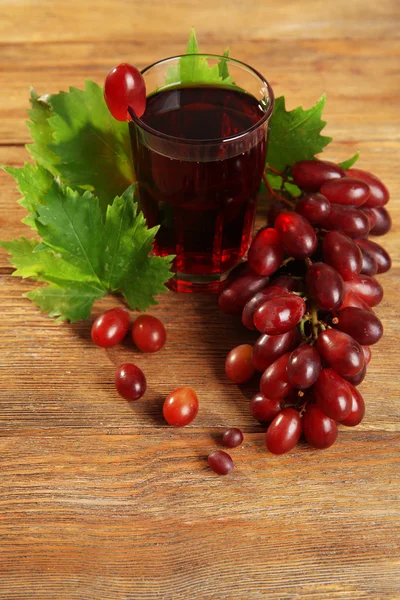 Glas druvsaft på trä bakgrund — Stockfoto