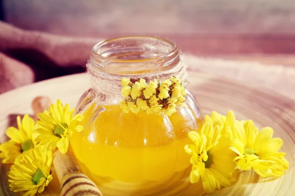 Honey with flowers and dipper — Stock Photo, Image