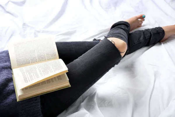 Frau in Jeans auf dem Bett — Stockfoto