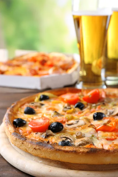 Pizza served with beer on wooden table — Stock Photo, Image