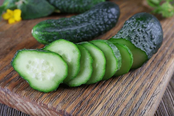 Sliced cucumbers on wooden background — Stock Photo, Image