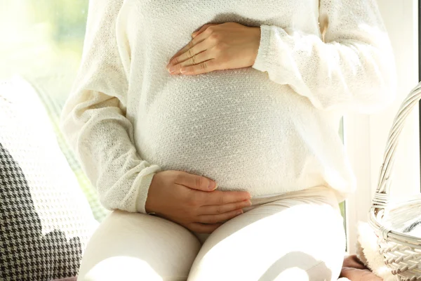Беременная женщина сидит на доске для окон — стоковое фото