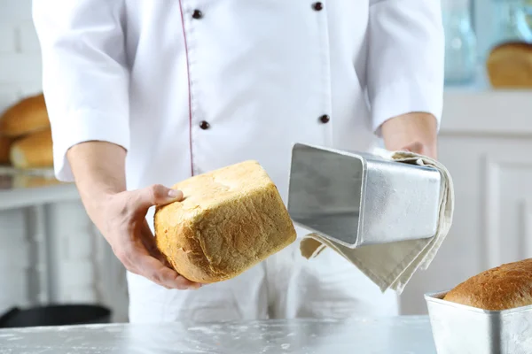 Baker checking freshly baked bread — Stock Photo, Image