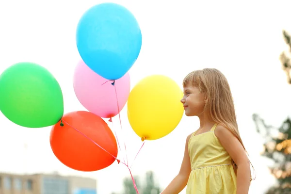 Little girl with balloons — Stock Photo, Image