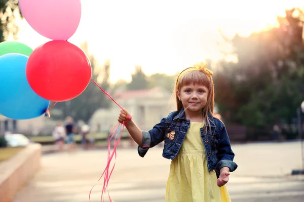 Liten flicka med ballonger — Stockfoto