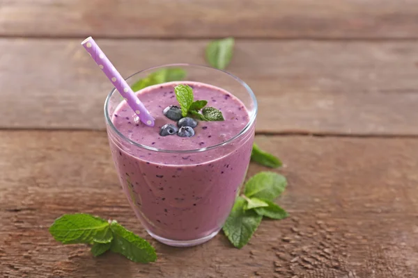 Leckerer Blaubeerjoghurt mit Beeren und Minze auf Holzgrund dekoriert — Stockfoto