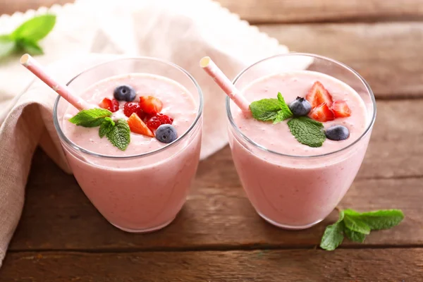 Yogurt alla fragola fresco e serviette su sfondo di legno, primo piano — Foto Stock