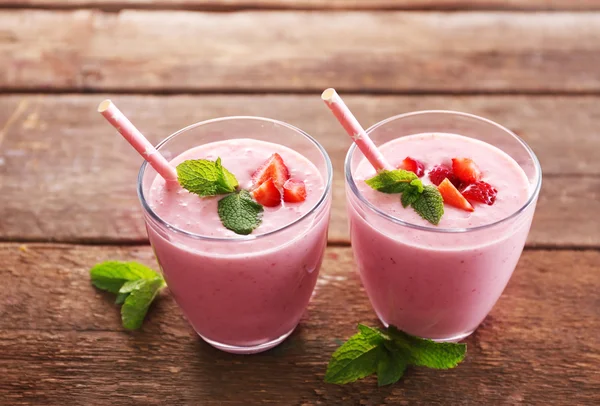 Yogurt alla fragola fresco con menta su sfondo di legno — Foto Stock