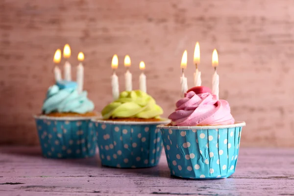 Tasty cupcakes with candles — Stock Photo, Image