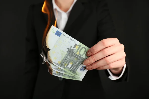 Woman burning Euro banknotes Stock Picture