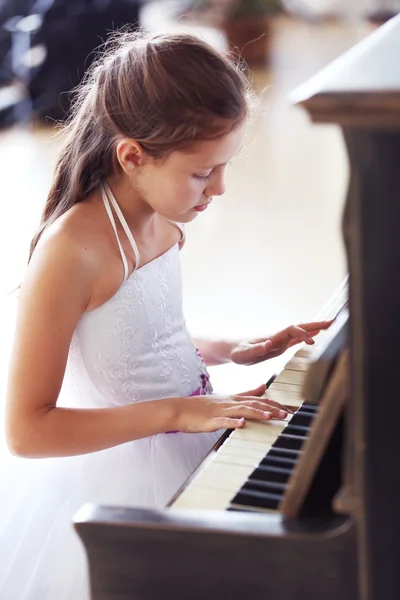 Prinses meisje speelt piano — Stockfoto