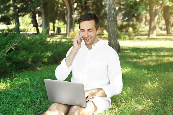 Man med laptop på grönt gräs — Stockfoto