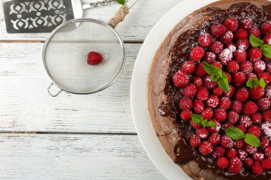 Kek çikolata sır ve ahududu rengi ahşap arka plan üzerinde