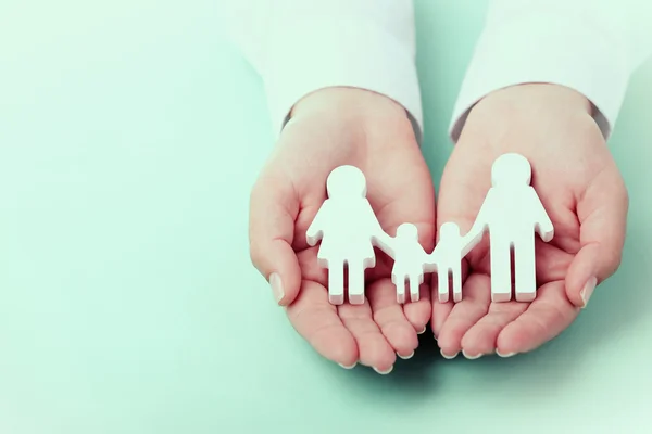 Vrouwelijke handen met speelgoed familie — Stockfoto