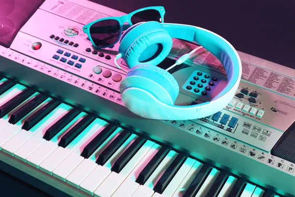 Headphones with sunglasses on synthesizer — Stock Photo, Image