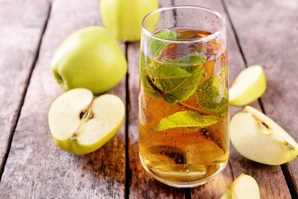 Стакан яблочного сока с фруктами и свежей мяты на столе крупным планом — стоковое фото