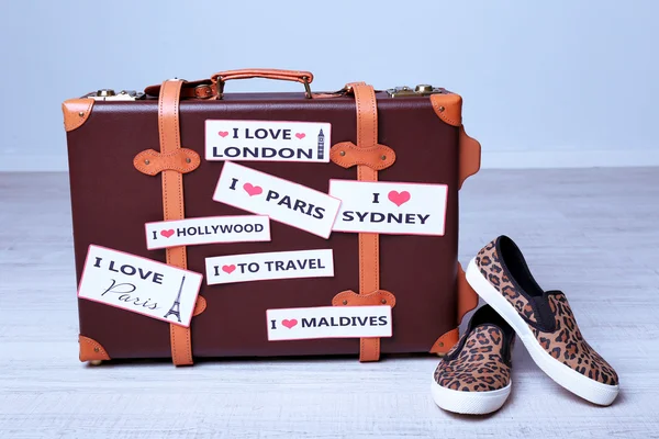 Suitcase with stickers on floor — Stock Photo, Image