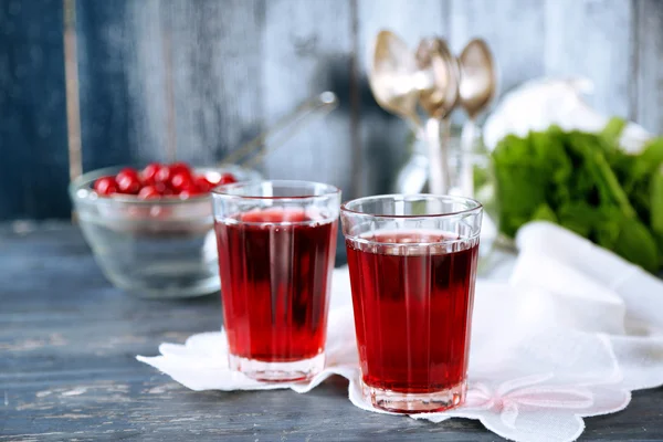 Sweet homemade cherry juice on table, on color background — Stock Photo, Image