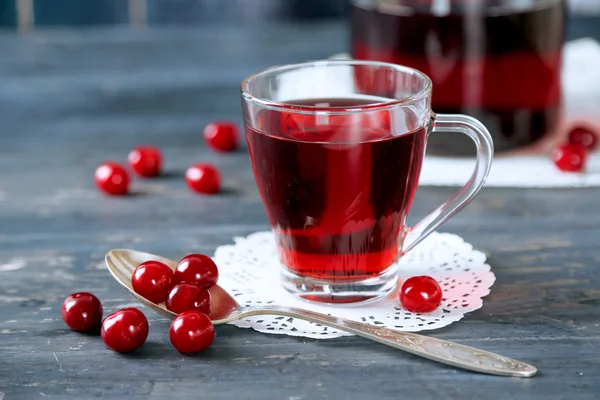 Süßer hausgemachter Kirschsaft auf dem Tisch, auf farbigem Holzhintergrund — Stockfoto