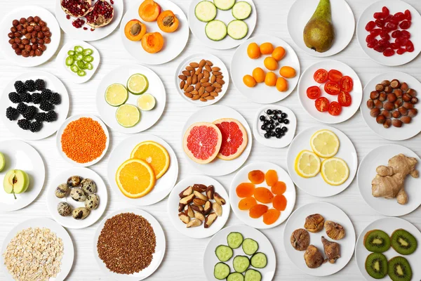 Different products on saucers on wooden table, top view — Stock Photo, Image