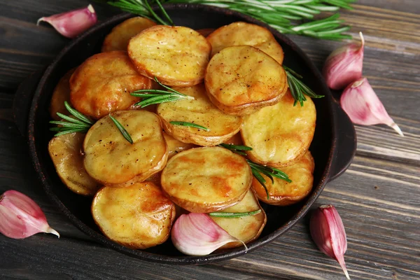 테이블에 프라이팬에 로즈마리와 함께 맛 있는 구운된 감자를 닫습니다. — 스톡 사진