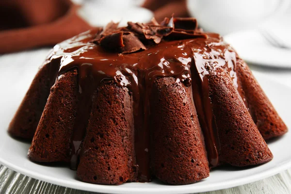 Delicioso pastel de chocolate con hielo en el plato en la mesa, primer plano — Foto de Stock