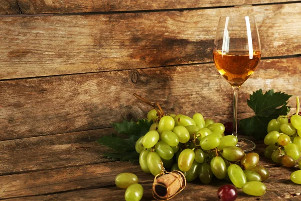 Grape with wine glass on wooden background — Stock Photo, Image