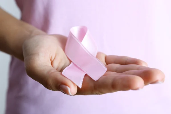 Pink ribbon in woman's hands — Stock Photo, Image