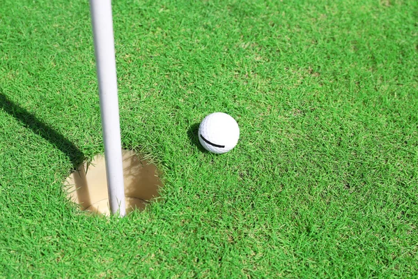 Bola de golfe no lábio do copo — Fotografia de Stock