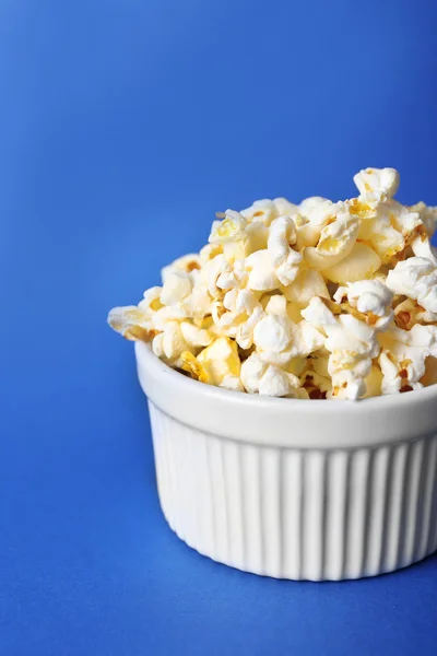 Salted popcorn on blue background — Stock Photo, Image