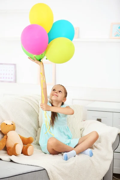 Маленькая девочка с плюшевым мишкой и воздушными шариками — стоковое фото