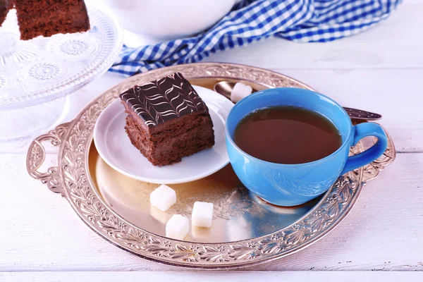 Served table with chocolate cake and a cup of tea on white wooden background — Stock Photo, Image