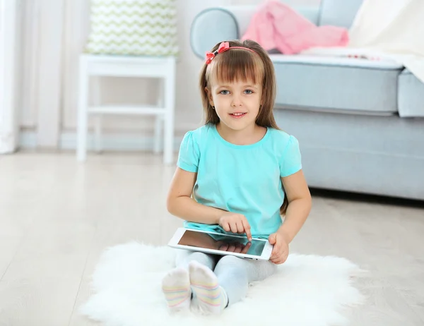 Kleines süßes Mädchen mit digitalem Tablet — Stockfoto