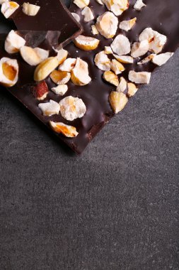 Siyah çikolata parçaları ve koyu gri arka plan üzerinde fındık
