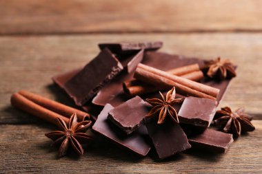 İle baharat ahşap arka plan üzerinde siyah çikolata parçaları