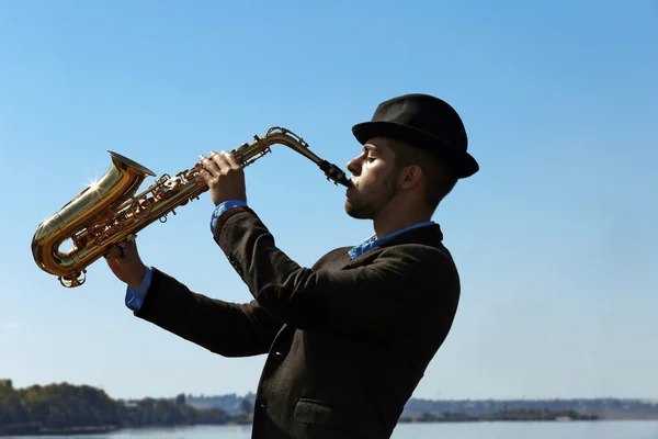 Saxofonista joga no cais — Fotografia de Stock