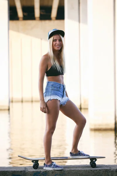 Mujer joven con tabla de patinar —  Fotos de Stock