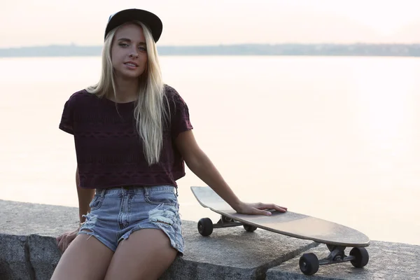 Mujer joven con tabla de patinar — Foto de Stock