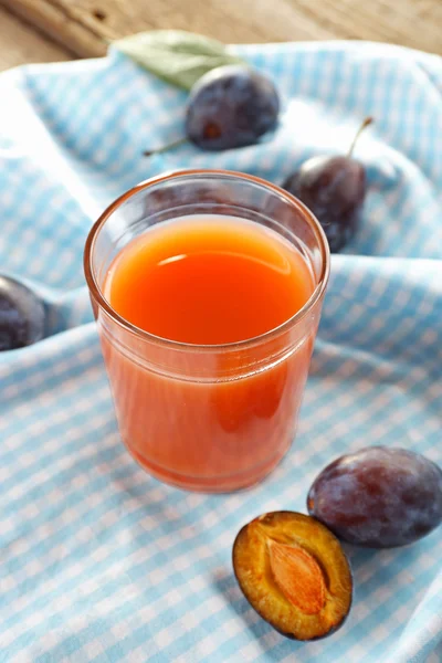 Сливовий сік у склянці зі свіжими фруктами — стокове фото