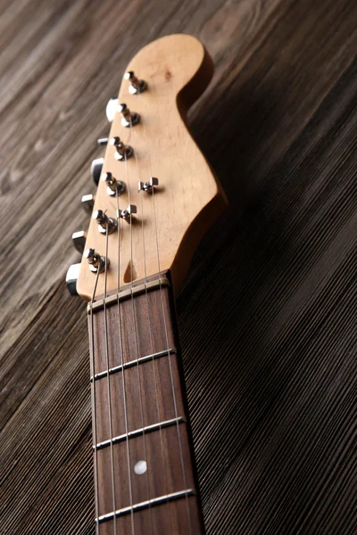 Guitarra 's fingerboard em fundo de madeira, close up — Fotografia de Stock