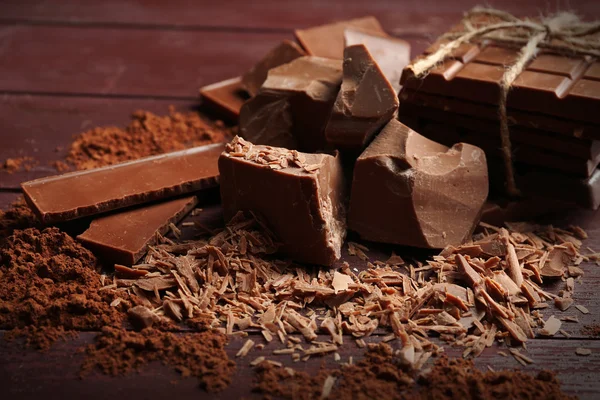 Fekete csokoládé darab, a fűszerek, a fából készült háttér — Stock Fotó