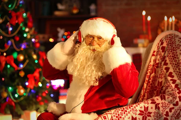 Santa Claus zitten met koptelefoon — Stockfoto